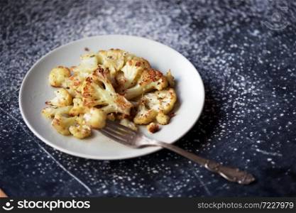 baked cauliflower in at the wooden table. french cuisine