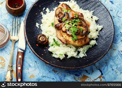 Baked chicken breast with marsala mushroom sauce and rice.. Chicken meat with mushroom sauce and rice