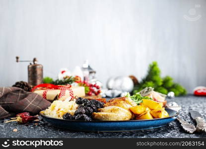 baked chicken breast with potatoes and olives on xmas background