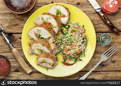 Baked chicken breast with vegetables and a side dish of risotto. Chicken stuffed with vegetables