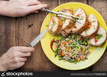 Baked chicken breast with vegetables and a side dish of risotto. Sliced grilled chicken breast