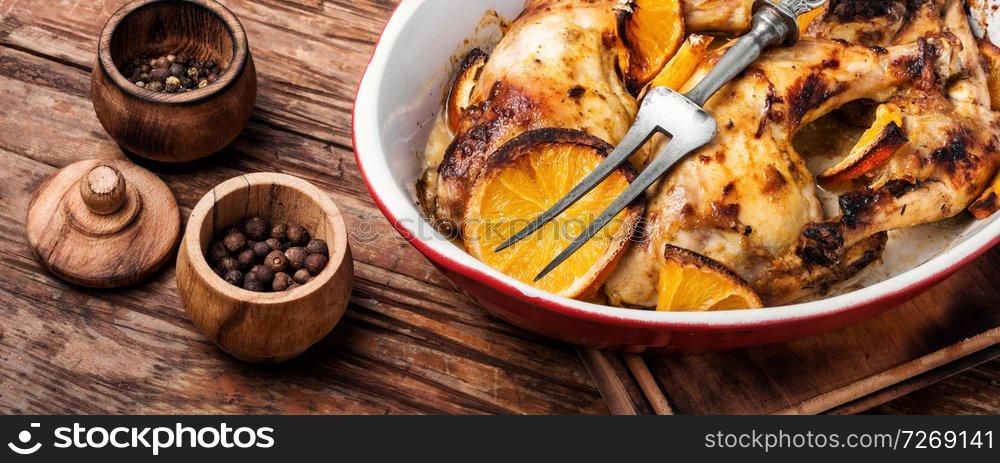 Baked chicken drumsticks with orange sauce in baking dish. Baked chicken with orange sauce