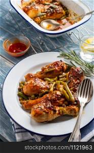 Baked chicken legs with peas, beans and fresh herbs. Chicken drumsticks with tasty sause and greens