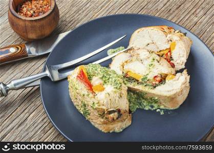 Baked chicken meat roll with vegetable and spinach filling. Delicious sliced turkey breast
