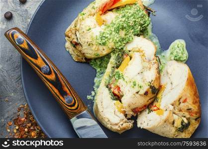 Baked chicken meat roll with vegetable and spinach filling. Rolled chicken stuffed with spinach