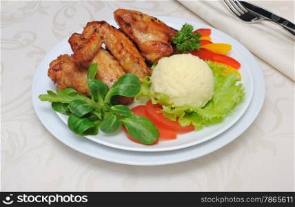 Baked chicken wings in honey and soy marinade with garlic and potatoes and vegetables
