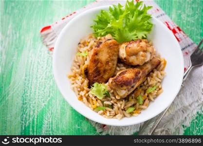 Baked chicken wings with rice in a bowl, sauces on side, selective focus