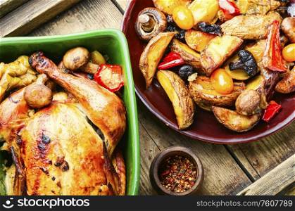 Baked chicken with apples on old wooden table.Fried chicken with apples.Tasty aromatic rotisserie chicken. Baked chicken with apples.