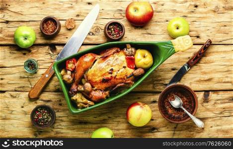 Baked chicken with apples on old wooden table.Fried chicken with apples.Roasted chicken with apples in baking dish. Baked chicken with apples.