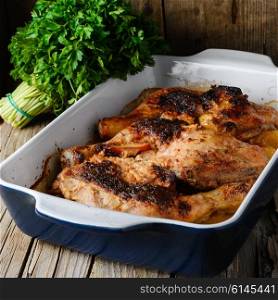 Baked chicken with orange. Baked chicken in a porcelain form on a rustic recipe