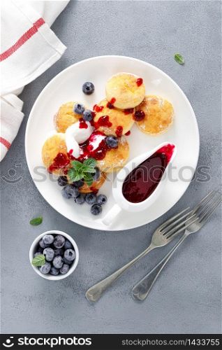 Baked cottage cheese pancakes, syrniki with yogurt, blueberry sauce and fresh berries