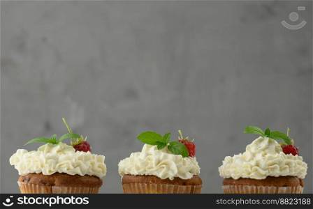 Baked cupcakes with white butter cream on the table, delicious dessert