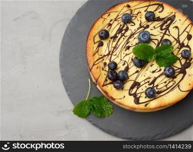 baked curd casserole on a black plate, top view, tasty and healthy dessert, copy space