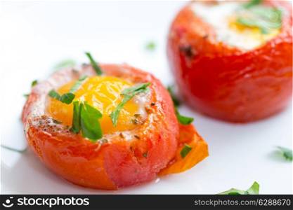 Baked, de-seeded tomatoes filled with an egg and finished in the oven, served on toast with a parsley garnish. This Italian dish is uova al piatto con pomodori