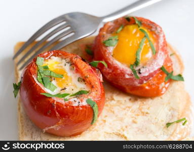 Baked, de-seeded tomatoes filled with an egg and finished in the oven, served on toast with a parsley garnish. This Italian dish is uova al piatto con pomodori