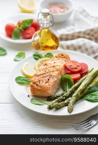 Baked Delicious salmon, green asparagus with vegetables on plate 