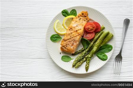Baked Delicious salmon, green asparagus with vegetables on plate 