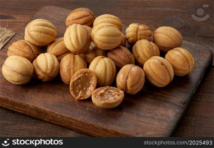 baked dessert nuts with condensed milk on a wooden board, top view