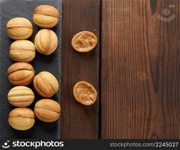 baked dessert nuts with condensed milk on black slate board, top view