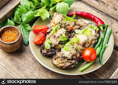 Baked eggplant with vegetables.Roasted vegetables on plate. Halved baked eggplant.