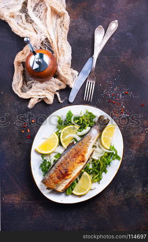 baked fish on plate and on a table