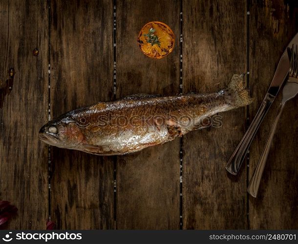 baked fish on wooden boards, top view. dish on a wooden surface