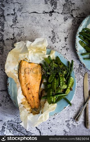 Baked fish with beans on rustic background