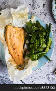 Baked fish with beans on rustic background