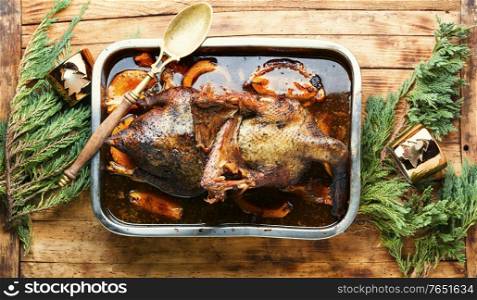 Baked goose stuffed with pumpkin and mushrooms.Christmas roast goose.Baked goose with pumpkin in baking dish. Baked stuffed goose