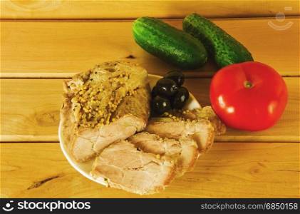 Baked ham on a plate on a wooden surface
