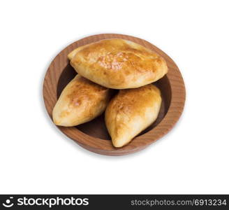 baked homemade patties with a filling in a wooden bowl isolated on a white background