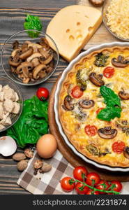 Baked homemade quiche pie with tomato, chcken and mushrooms in ceramic baking form, eggs and cream isolated on white background. Baked homemade quiche pie in ceramic baking form, eggs and cream