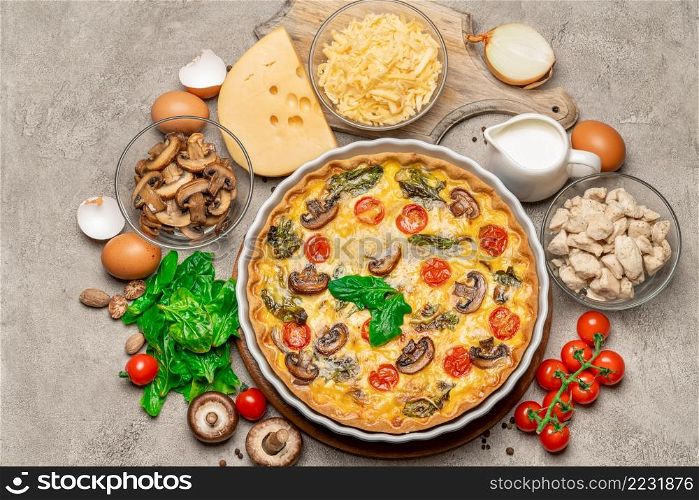 Baked homemade quiche pie with tomato, chcken and mushrooms in ceramic baking form, eggs and cream isolated on white background. Baked homemade quiche pie in ceramic baking form, eggs and cream
