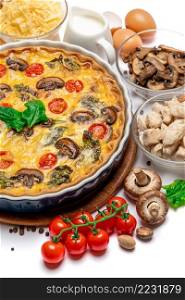 Baked homemade quiche pie with tomato, chcken and mushrooms in ceramic baking form, eggs and cream isolated on white background. Baked homemade quiche pie in ceramic baking form, eggs and cream