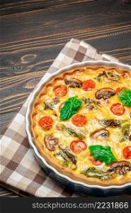Baked homemade quiche pie with tomato, chcken and mushrooms in ceramic baking form. Baked homemade quiche pie in ceramic baking form