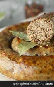 baked homemade sausage with spices and herbs, close up. Spiral grilled homemade sausage.