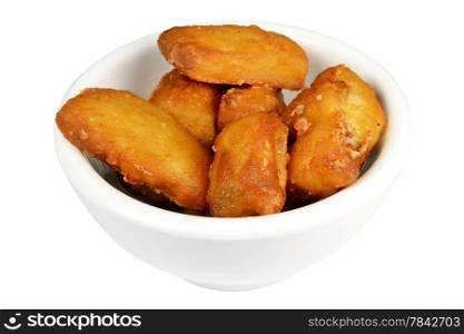 Baked kibbeling fish in a bowl on a white background.