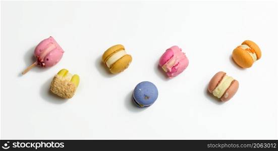 baked macarons with different flavors on a white background, top view