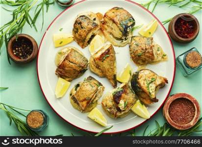 Baked mackerel with onions,tarragon herbs and spice. Sliced baked mackerel on an onion pillow