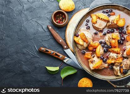 Baked meat in red wine with apricot in iron cast pan.Copy space. Stew meat with apricot.