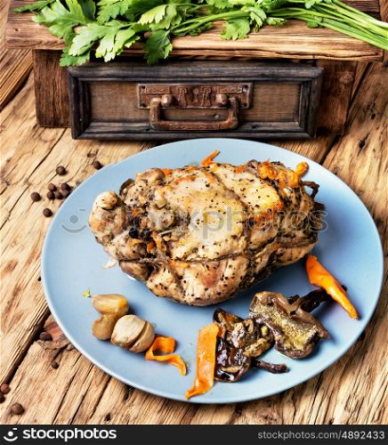Baked meat, stuffed with mushrooms. Baked meat grill with mushrooms on a wooden background