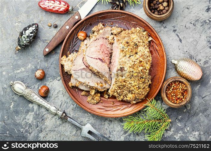 Baked meat under a bread crust with nuts. Roasted beef for Christmas
