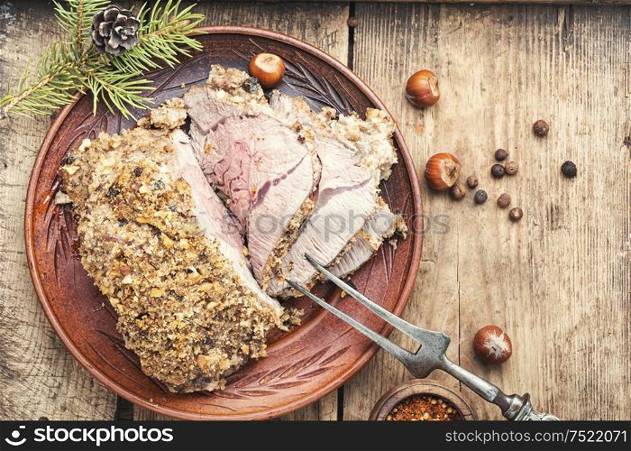 Baked meat under bread crust with nuts.Space for text. Roasted beef for Christmas