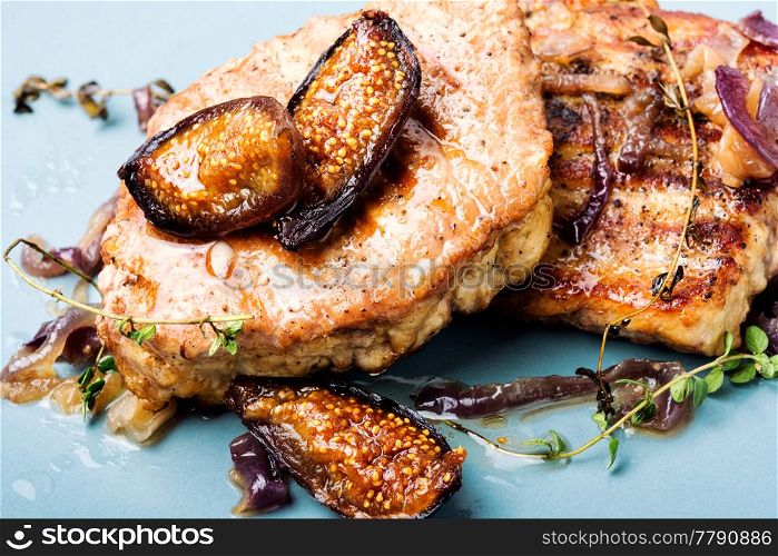 Baked meat with onion and figs on plate.Steak with figs sauce. Meat steak with fig and thyme