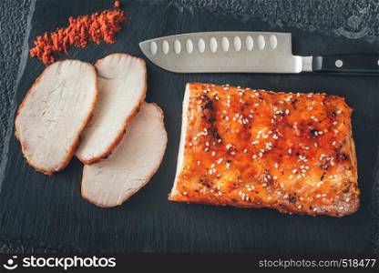 Baked meat with paprika on the black sone board: top view