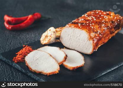 Baked meat with paprika on the black sone board: top view