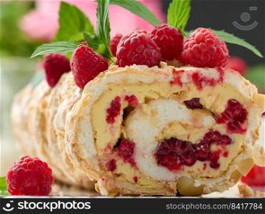Baked meringue roll with cream and fresh red raspberry, close up