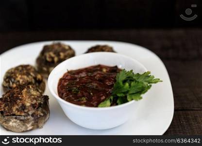 baked mushrooms with meat and sauce on a plate and wood