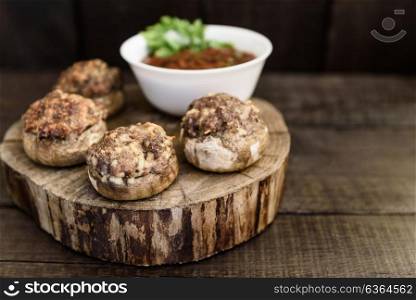 baked mushrooms with meat and sauce on a wood