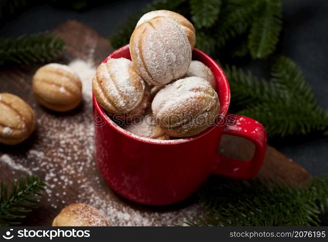 baked nut-shaped dessert in a red ceramic mug sprinkled with powdered sugar, top view